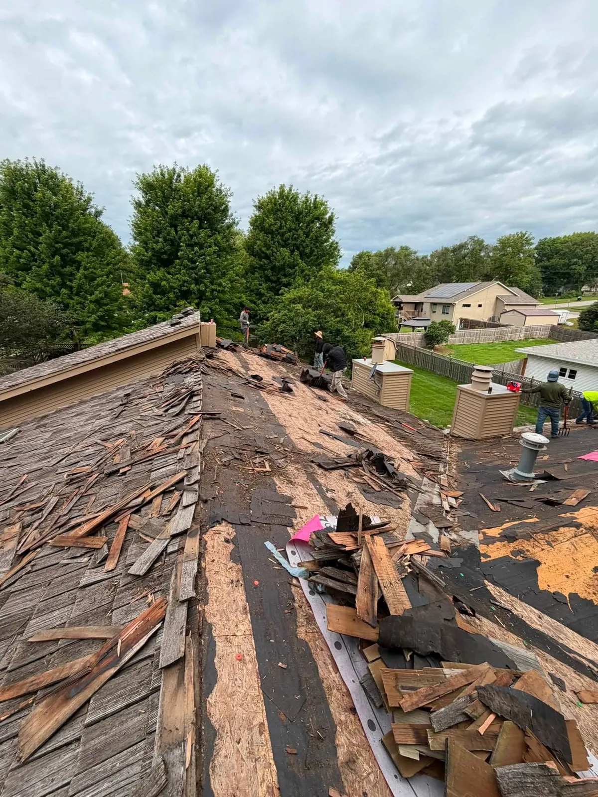 Snap Roofing crew stripping an old roof down to the deck in Brooklyn